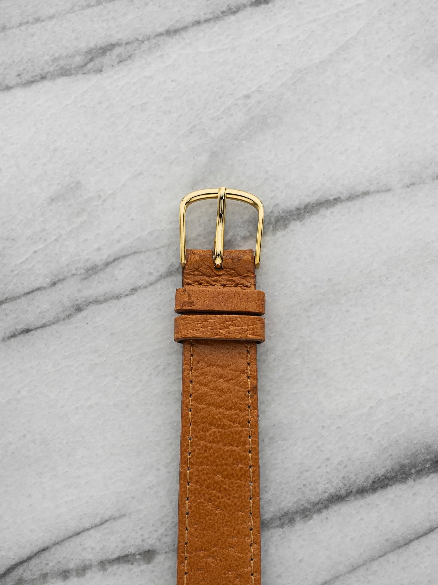 May be an image of leather, wrist watch and saddle-stitched leather