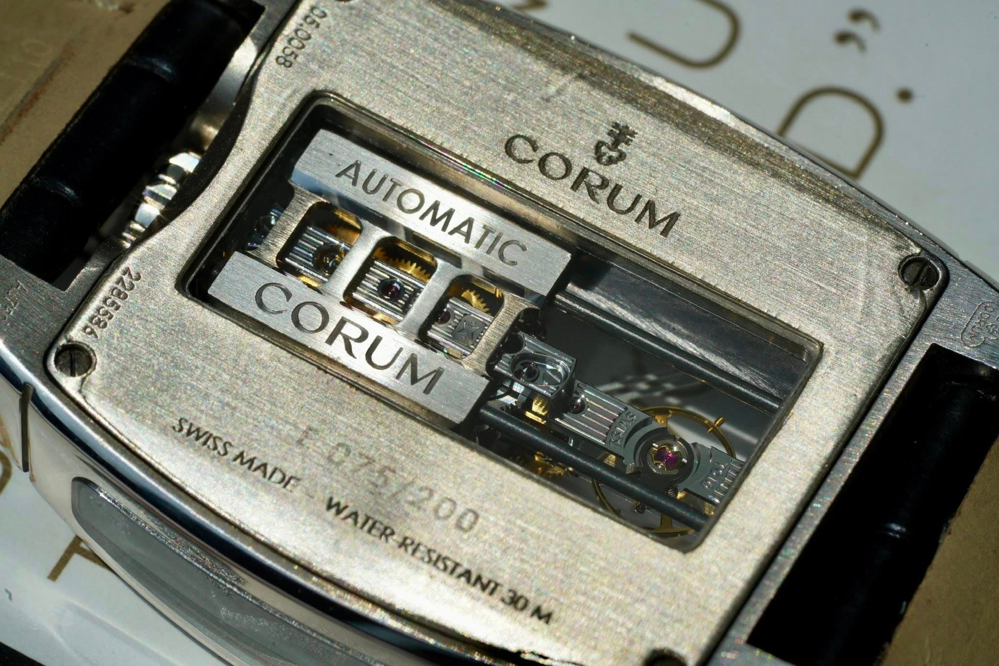 May be an image of digital watch and text that says ' - に AUTOMATIC CORUM ま CORUM SWISSMADE MADE SWISS SWISS MADE WATER WATER 075/200 RESISTANT RESISTANT30 30M 30'