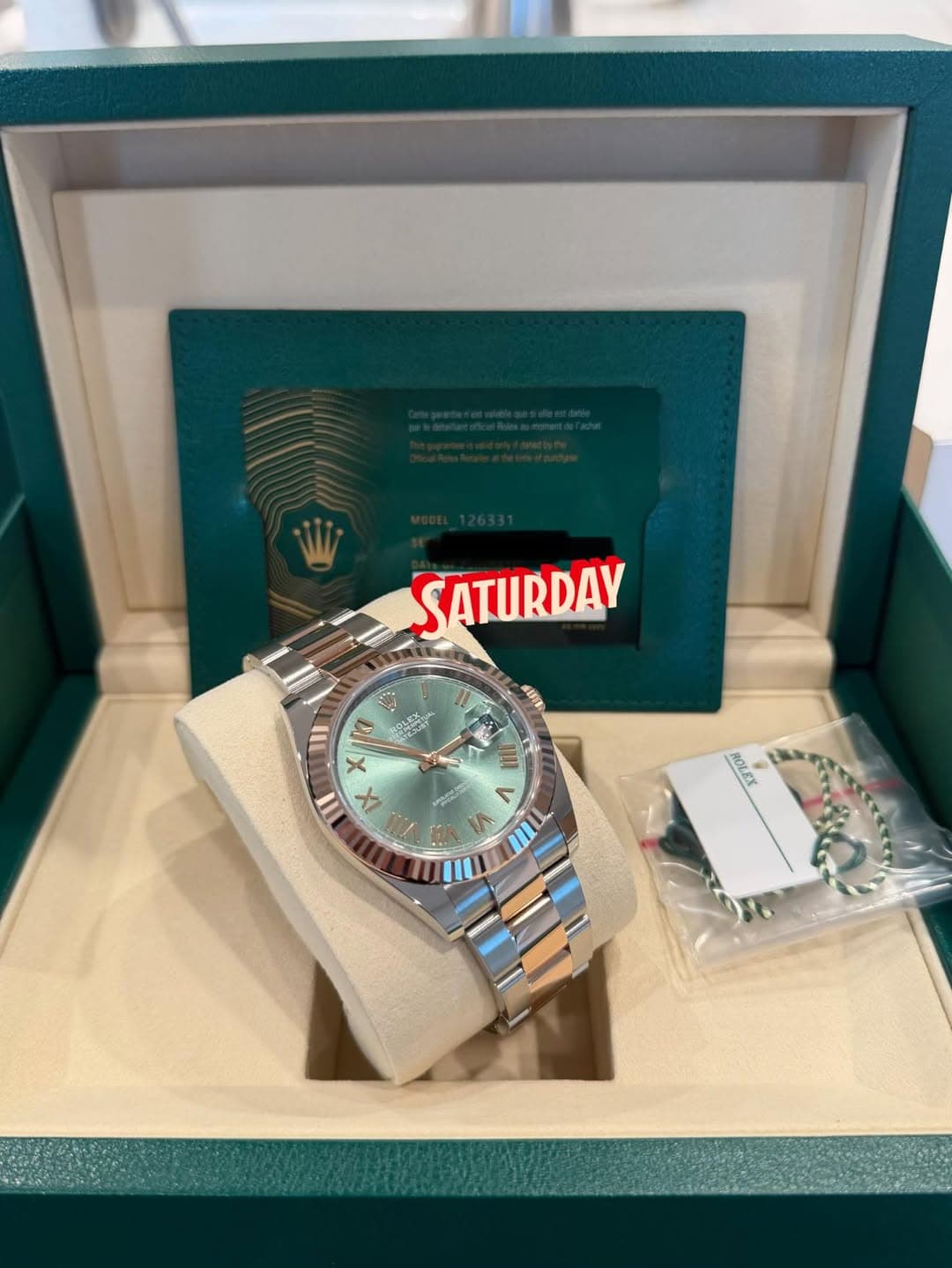 May be an image of wrist watch and text that says 'SATURDAV AUA क III ra X II IX መለጌን < ۱ n ROLEX ROUE OLEY'