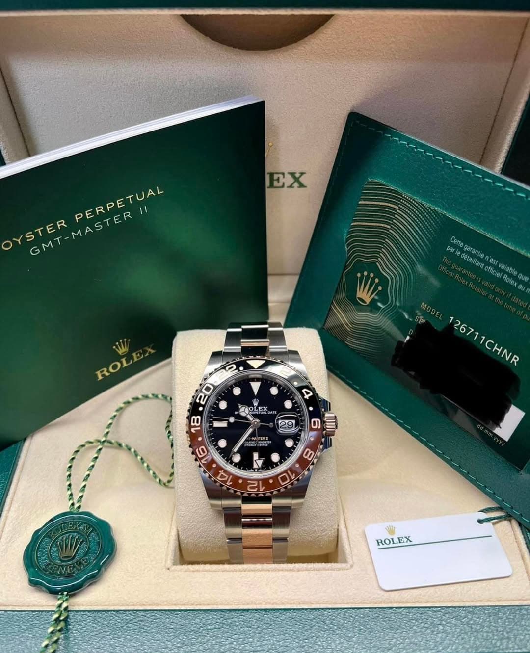 May be an image of wrist watch and text that says 'EX PERPETUAL YSTER GMT-MASTERII VETERPESRETYA GMT MASTER par Cen gerantie បានានែ n'es ASE fcielRolex estvaiable MODEL 126711CHNR…