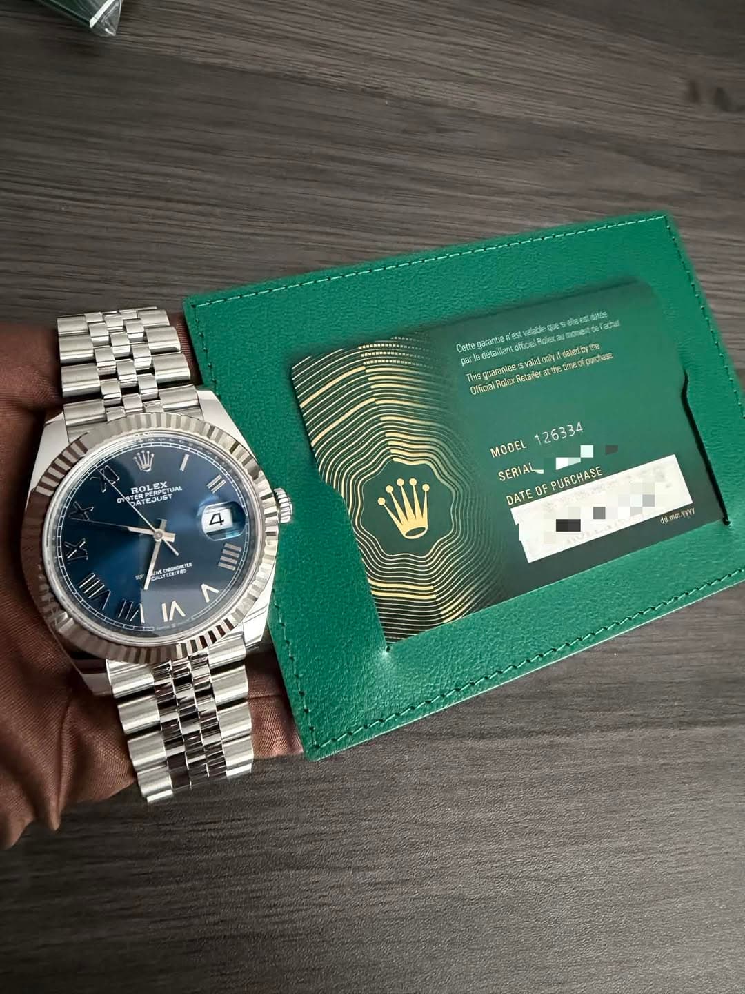 May be an image of wrist watch, saddle-stitched leather, leather wallet and text