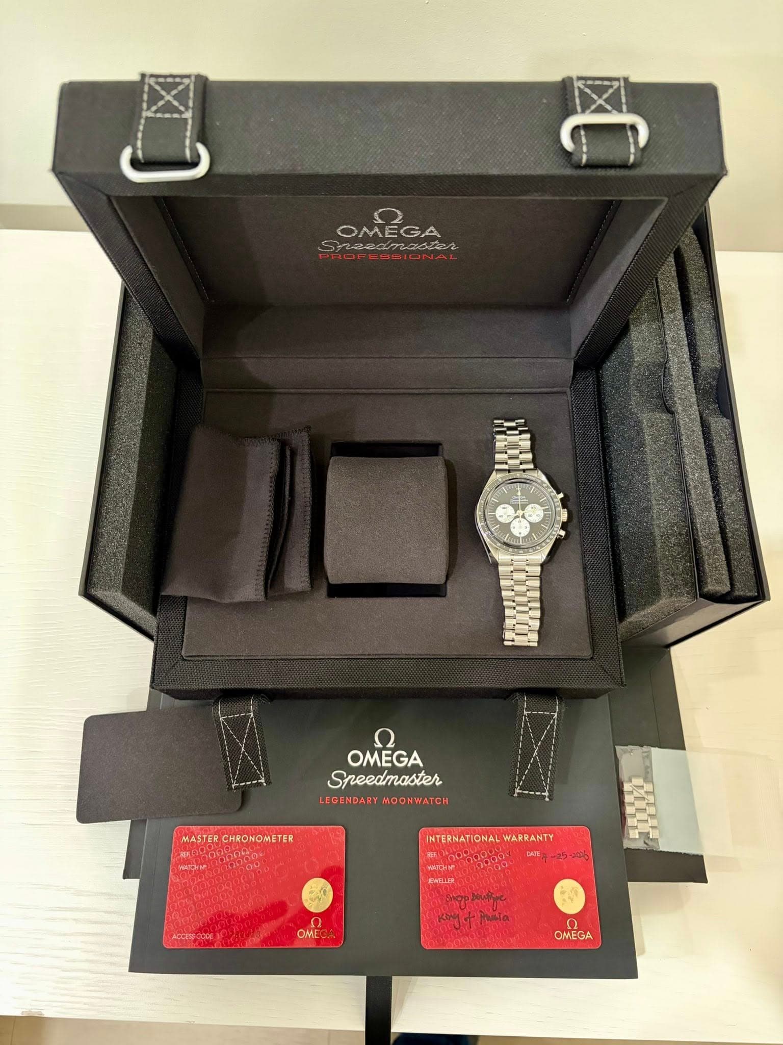 May be an image of wrist watch and text that says 'OMEGA مم wedmaduen Sneedmaster 73 ಒಡದలలబఓ חע OMEGA Sreedmaster LEGENDART MO MOONWATCH W MASTERC MASTERCHRONOMETER CHRONOMETER…
