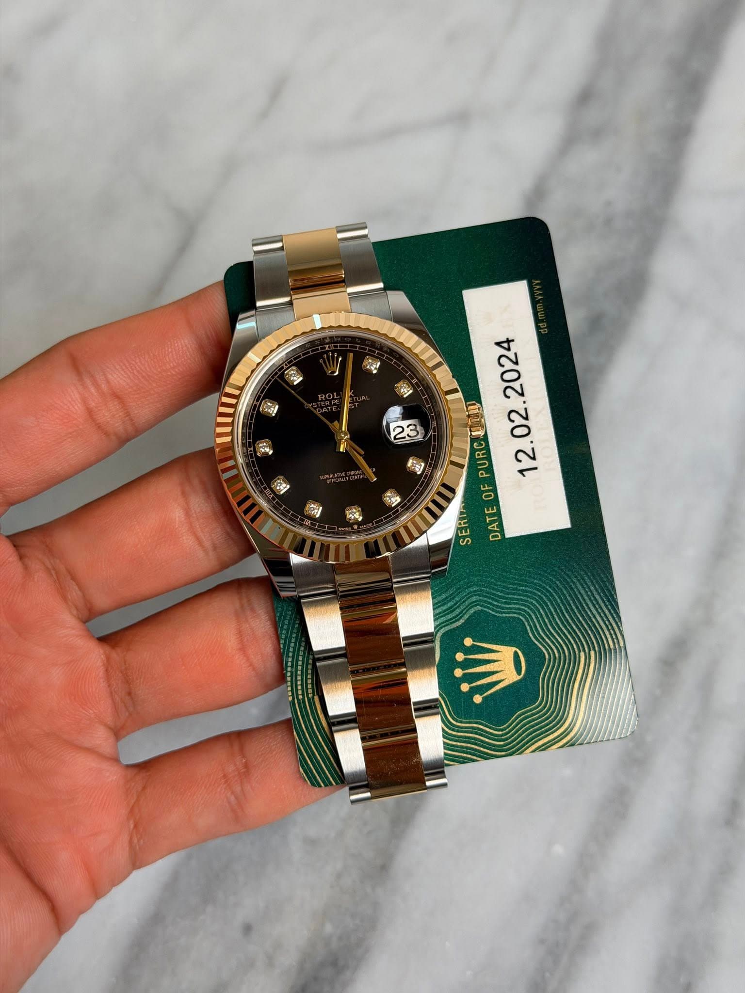 May be an image of wrist watch and text that says 'ญี้ A 퍼 By 23 迎 肉 タ ผู้สั่ง 2024 02. PURC . OF DATEO SERI DATEOFPURC'
