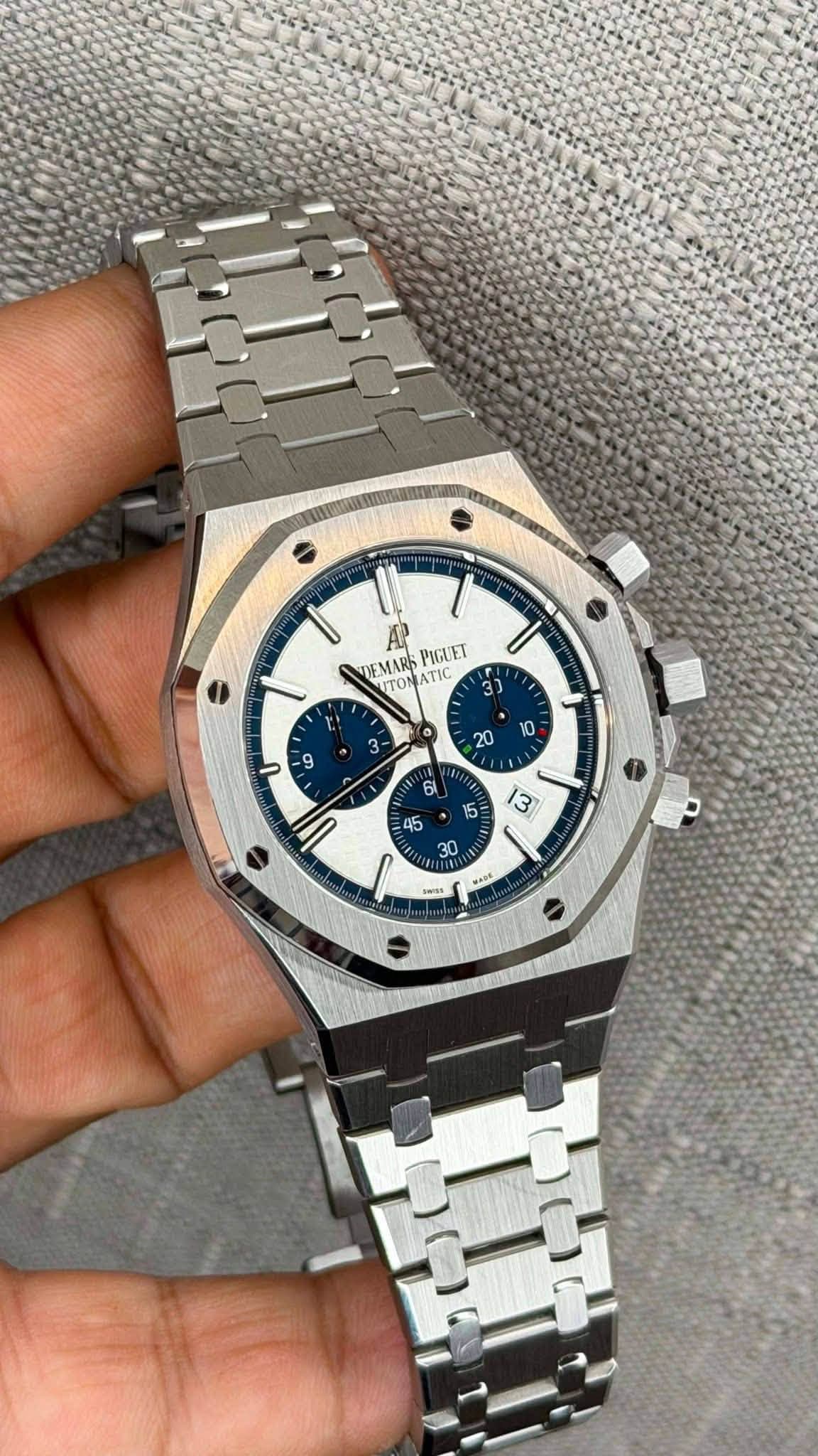 May be an image of wrist watch and text that says '| DEMARS ATI PIGUET ITON 3 ٢ / 45 0 5 ١ .aDh'