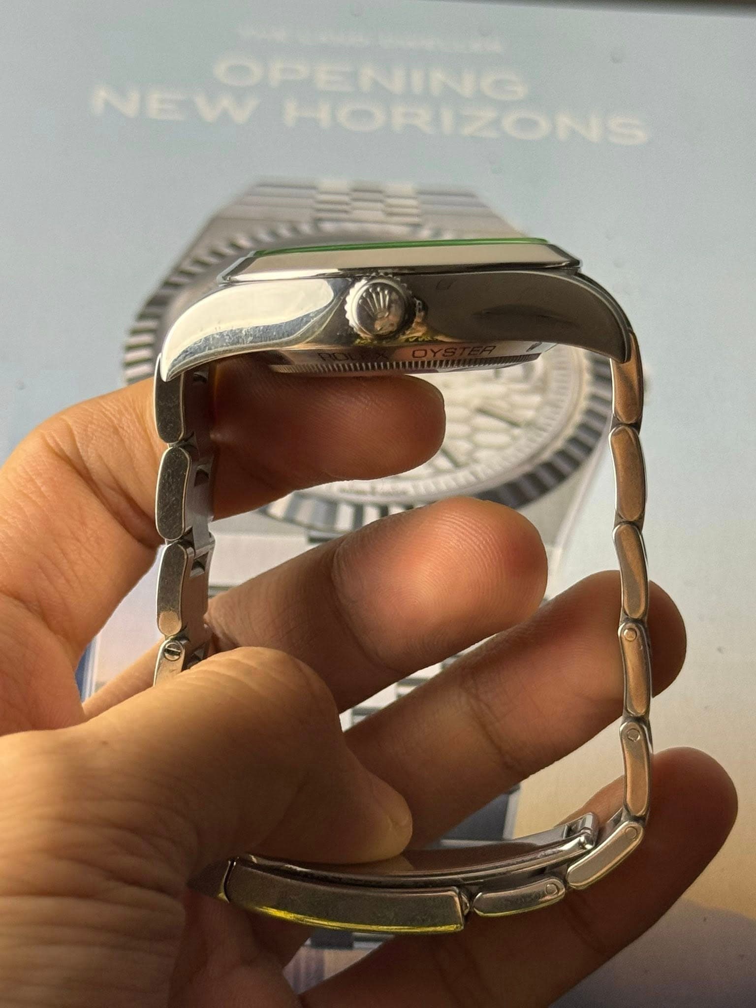 May be an image of wrist watch and text that says 'OPENING NEW HORIZONS'