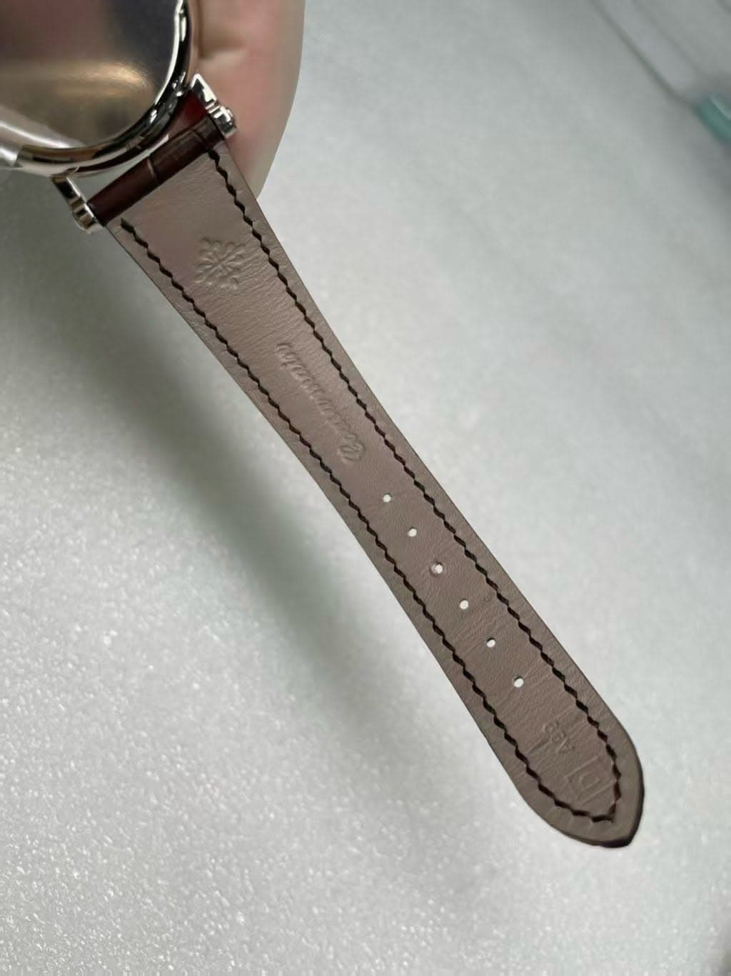 May be an image of wrist watch, leather and saddle-stitched leather