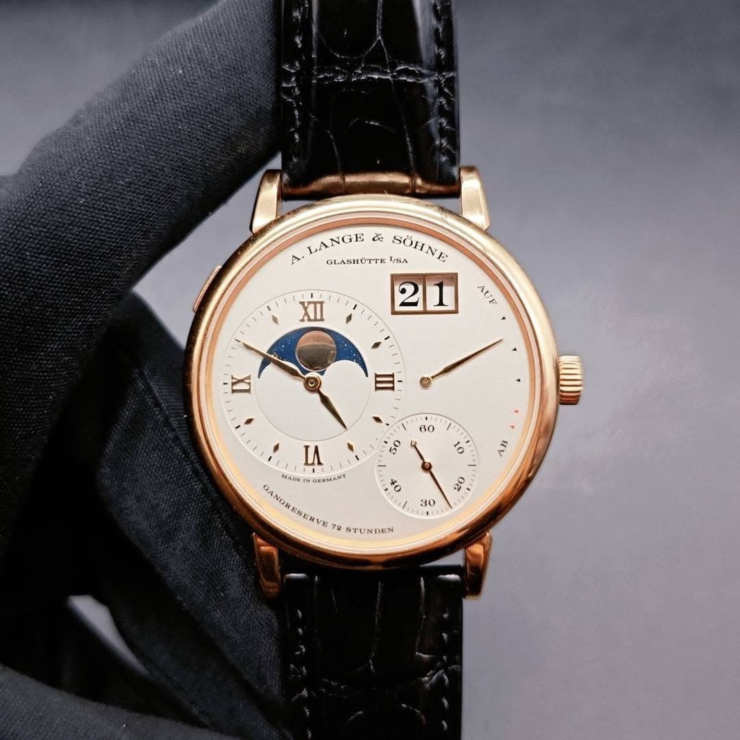 May be an image of wrist watch and text that says 'LANGE 歌 A. ЛROTTK 1/8A SÖHNE 21 XII AUE บา IX E / 220 0 H0 IA NADET AKИMAy GANORESENVI 7g STUNDEN 30 TEE'