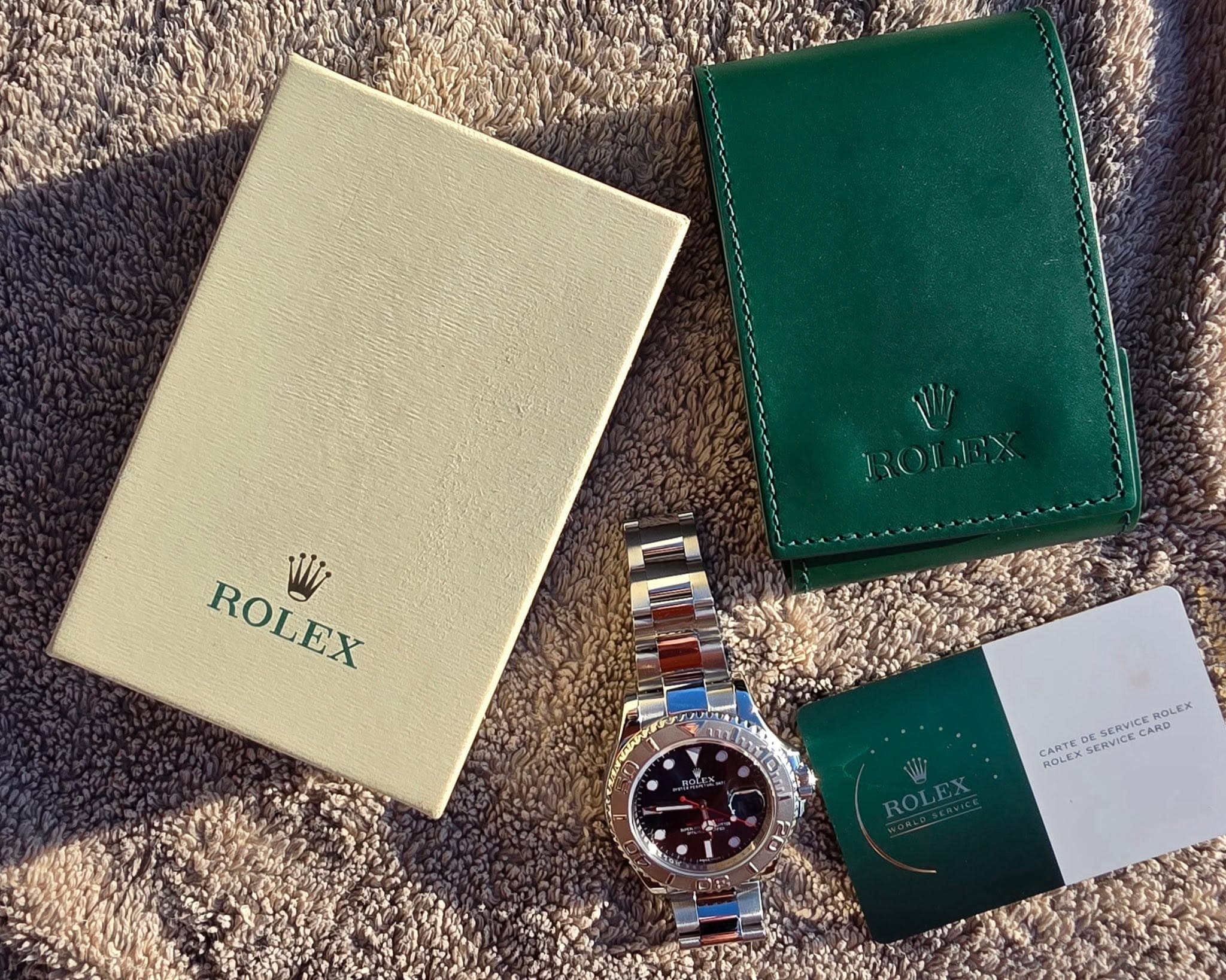 May be an image of wrist watch, leather wallet and text that says 'க ROLEX W ROLEX CAND SE.O AR CARTE ROLEX SCRVI SERVICE SERVICE ROLEX'