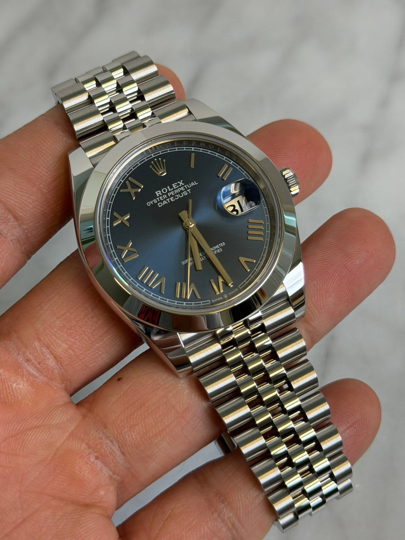 May be an image of wrist watch and text that says 'ROLEX STERPERPETU DATE UAL 電国町 1|| ih ۰'