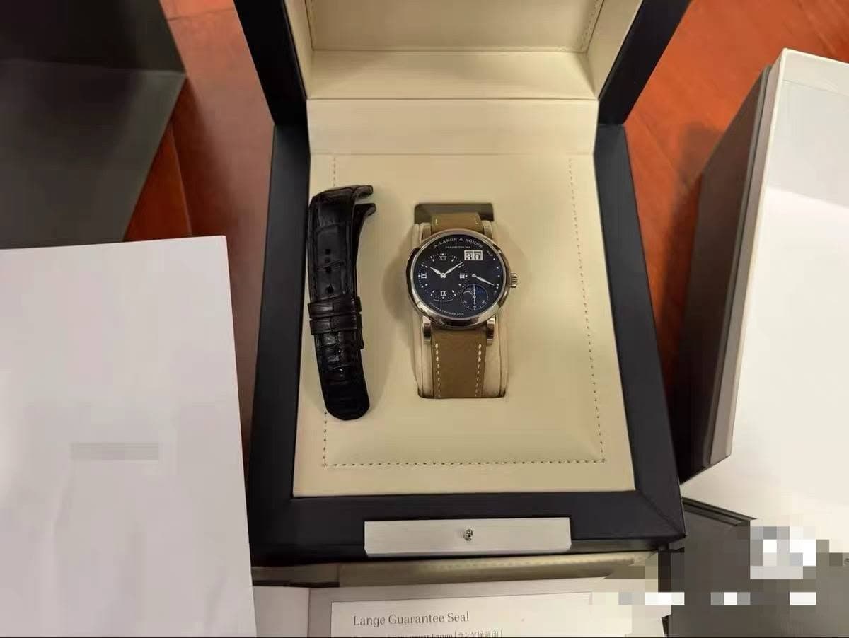 May be an image of digital watch and text that says 'ូួត Lange Guarantee LangeGuaranteeSeal Seal'