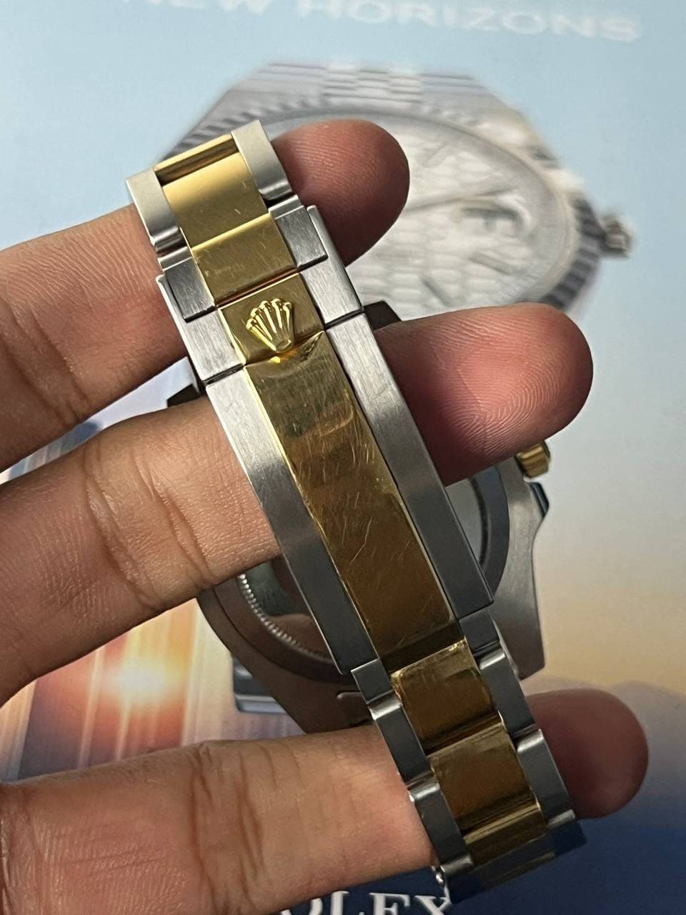 May be an image of wrist watch and text that says 'ብ ,r'