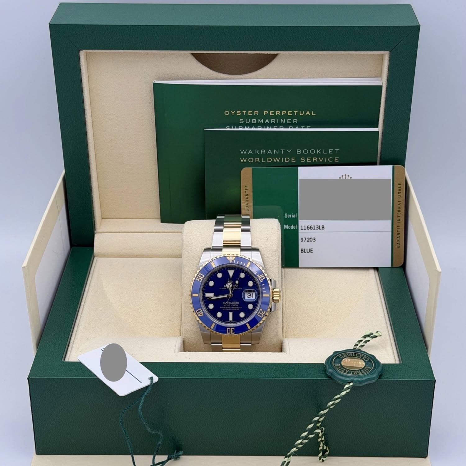 May be an image of wrist watch and text that says 'OYSTER OYSTERPERPETUAL PERPETUAL UBMARINER WORLDWIDESERVICE ERVICE WARRAN WORL WORLDWID WIDE nit Serial Model 116613LB 97203 BLUE…
