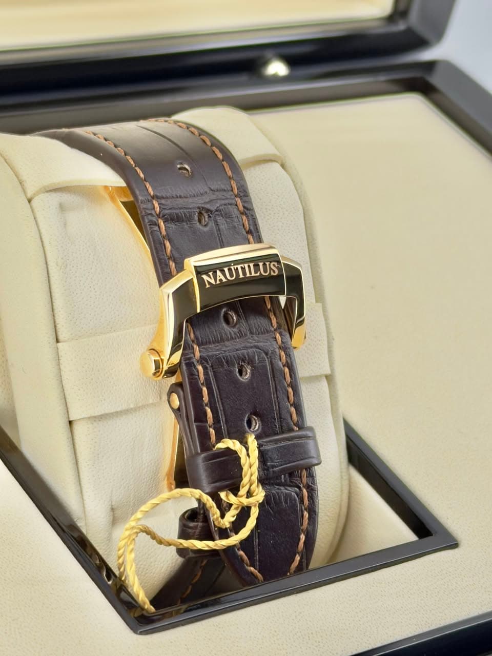 May be an image of leather, wrist watch and text that says 'NAUTILUS'