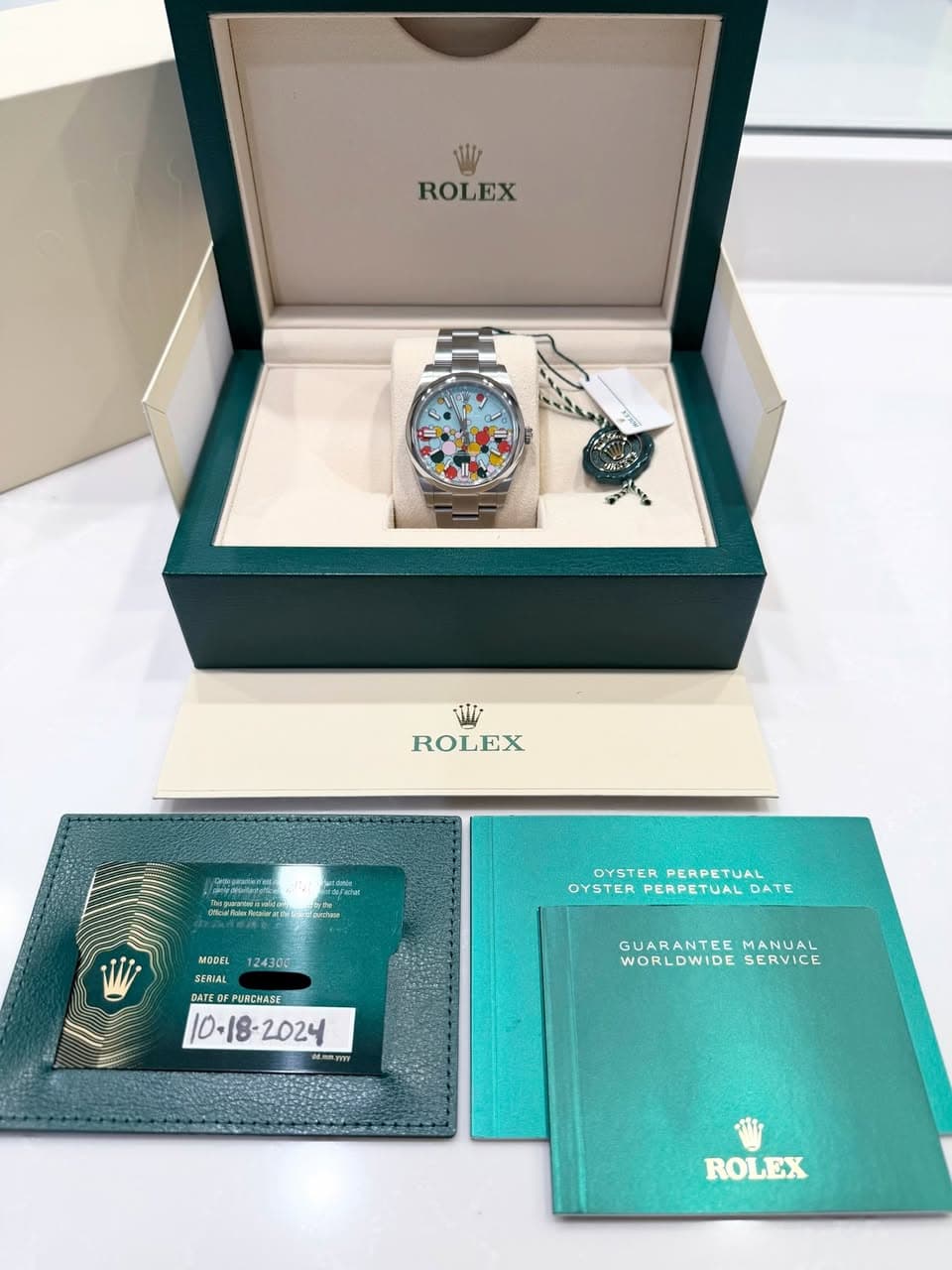 May be an image of wrist watch and text that says 'ROLEX تللك ROLEX eme ทิดทีบค๕ 124300 OYSTERPERPETUAL OYSTER PERPETUAL OYSTER PERPETUAL OYSTERPERPETUALDATE JAL DATE MODEL…