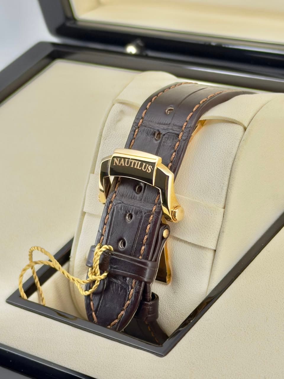 May be an image of leather, wrist watch and text that says 'NAUTILUS'