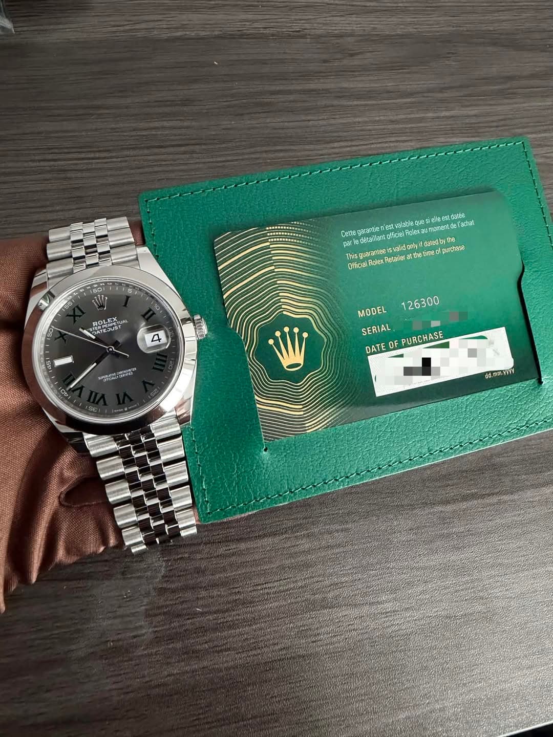 May be an image of leather wallet, wrist watch and text