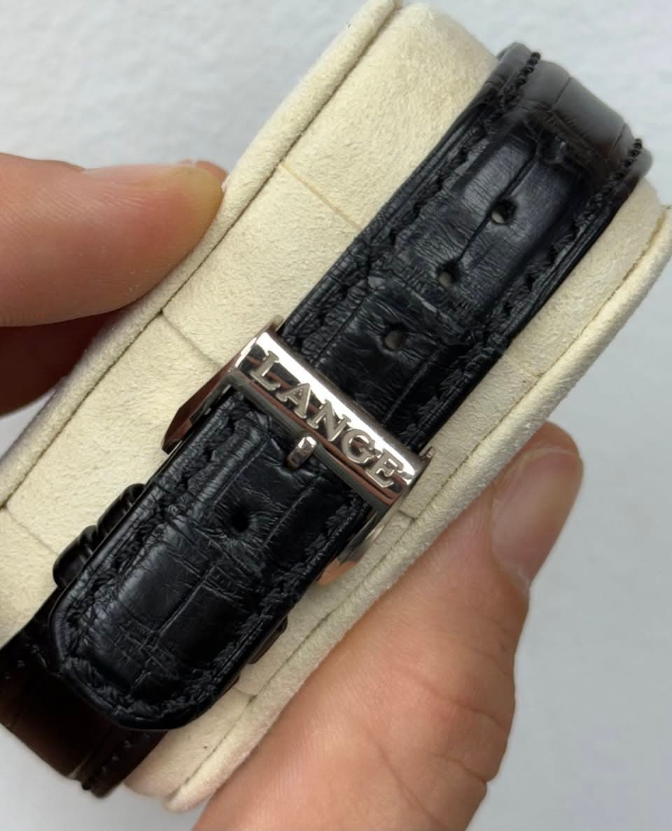 May be an image of wrist watch, leather and text